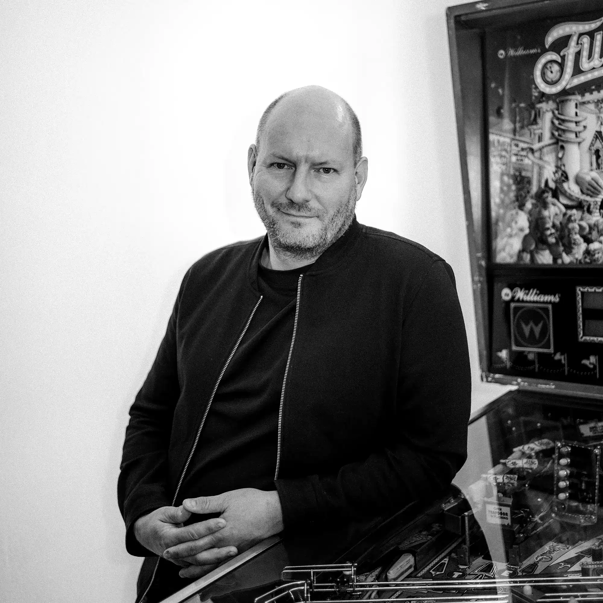 Oliver Zwack, Kreativdirektor der Design Agentur Ansichtssache München, vor einem Flipperautomaten