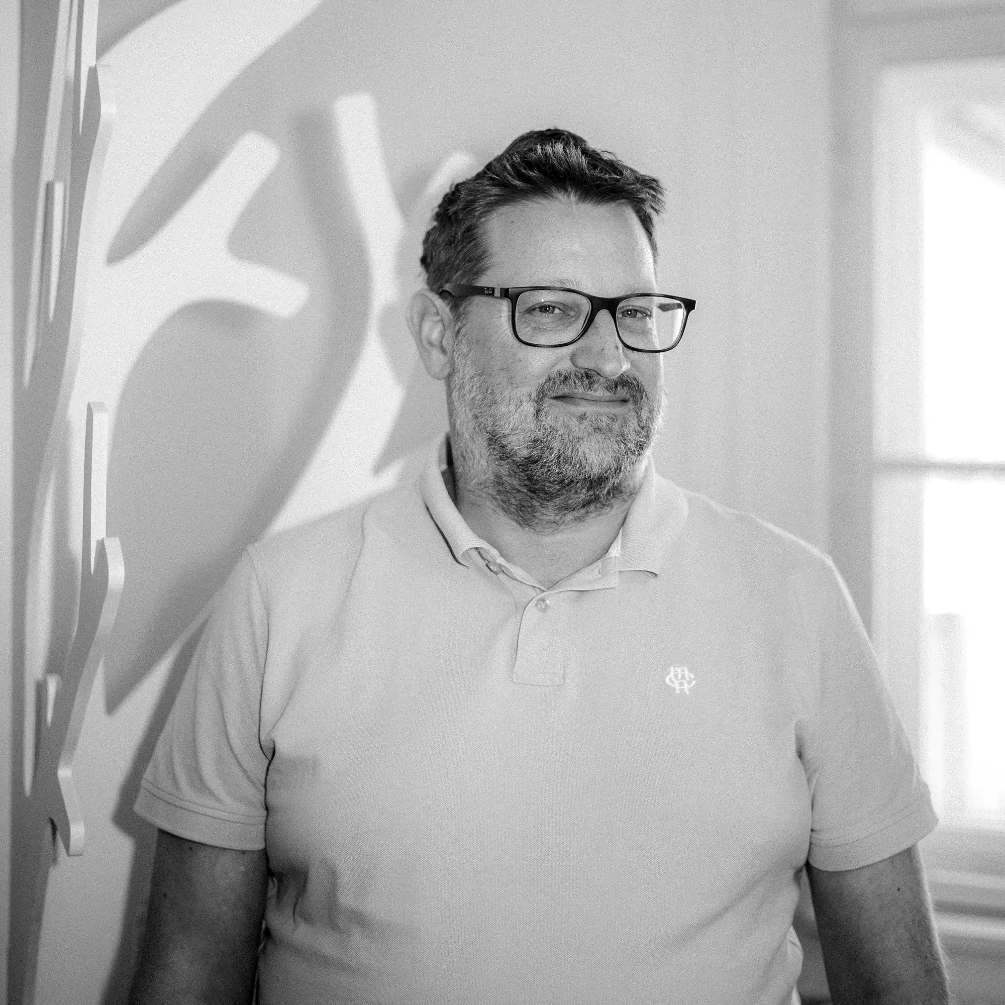Philip Schuh, Teammitglied der Design Agentur Ansichtssache München, Portrait in schwarz-weiß mit Brille